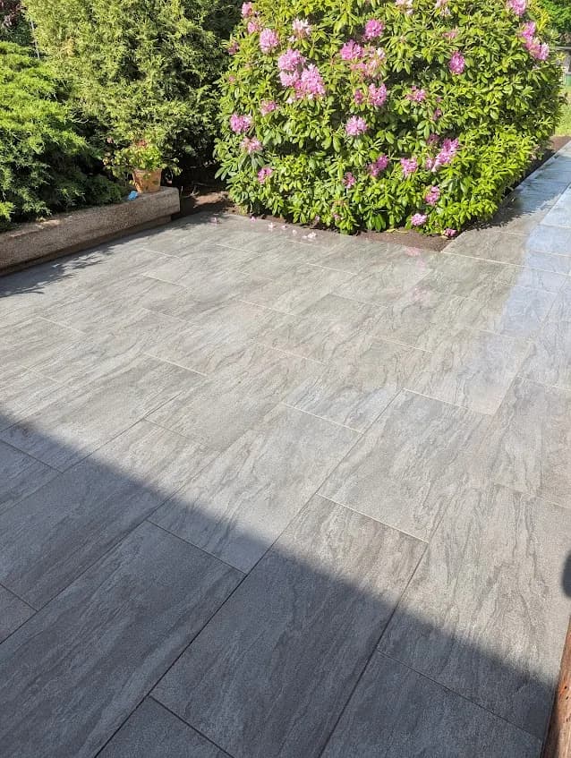 Terrasse aus grauen Naturstein-Platten am Rhododendron im Kreis Pinneberg